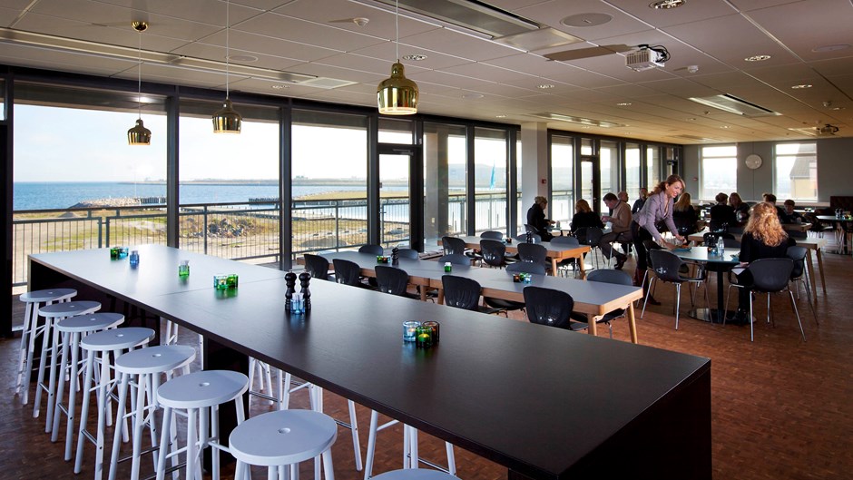 Medarbejdere i kontorhus spiser frokost med udsigt til Øresund