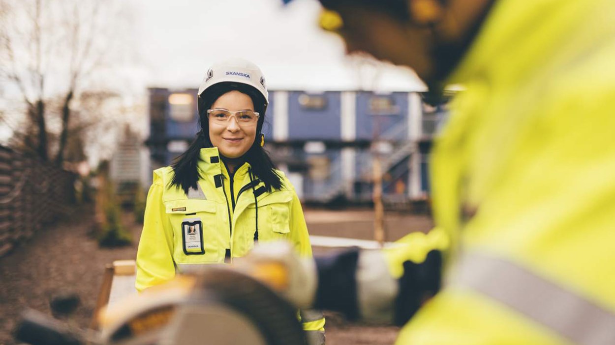 En kvindelig skanska medarbejder med smil og sikkerhedshjelm