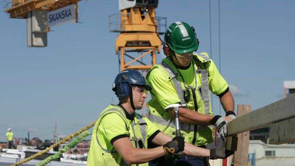 to skanska arbejdere i sikkerhedsudstyr arbejder